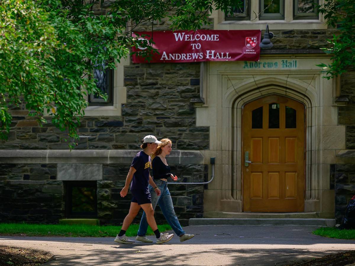 Two students walk past the entrance of Andrews Hall